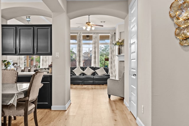 3422 Leaning Willow Dr, Katy, TX 77494 - interior space featuring crown molding, arched walkways, ceiling fan, and light wood-style flooring
