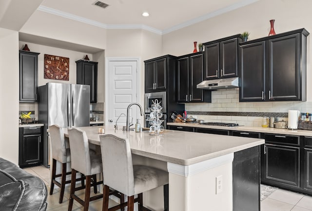 3422 Leaning Willow Dr, Katy, TX 77494 - kitchen featuring a sink, dark cabinetry, decorative backsplash, light tile patterned floors, and under cabinet range hood