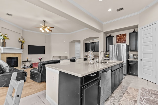 3422 Leaning Willow Dr, Katy, TX 77494 - kitchen featuring a sink, arched walkways, dark cabinetry, and light tile patterned flooring