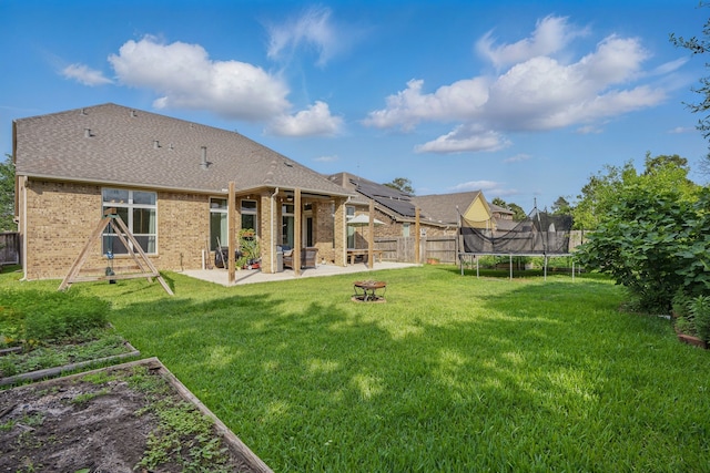 3422 Leaning Willow Dr, Katy, TX 77494 - back of house with a trampoline, a lawn, brick siding, a fenced backyard, and a patio