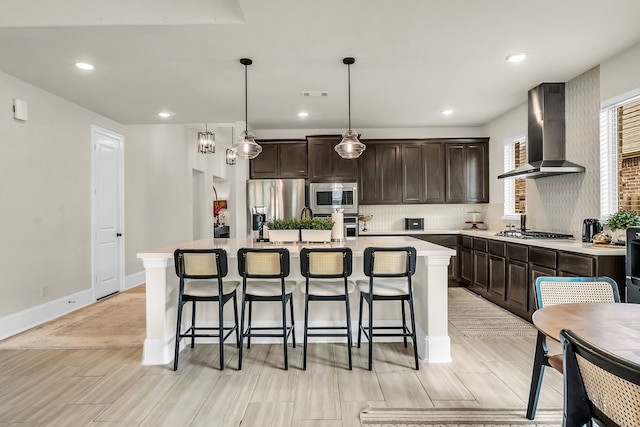 32927 Franklin Brooks Dr, Brookshire, TX 77423 - kitchen with appliances with stainless steel finishes, a kitchen bar, wall chimney exhaust hood, and an island with sink