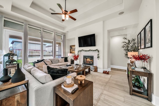 32927 Franklin Brooks Dr, Brookshire, TX 77423 - living room featuring a ceiling fan, visible vents, a glass covered fireplace, and a raised ceiling