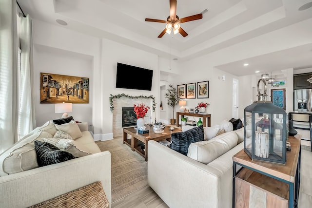32927 Franklin Brooks Dr, Brookshire, TX 77423 - living room with a raised ceiling, a glass covered fireplace, a ceiling fan, baseboards, and recessed lighting