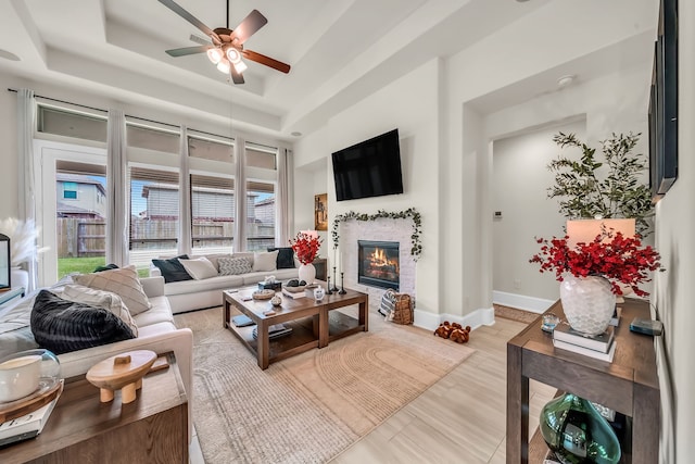 32927 Franklin Brooks Dr, Brookshire, TX 77423 - living room with a glass covered fireplace, baseboards, a ceiling fan, and a tray ceiling