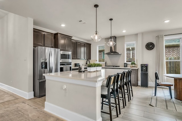 32927 Franklin Brooks Dr, Brookshire, TX 77423 - kitchen with wall chimney range hood, a kitchen island, appliances with stainless steel finishes, dark brown cabinets, and recessed lighting