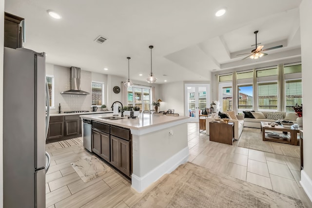 32927 Franklin Brooks Dr, Brookshire, TX 77423 - kitchen featuring wall chimney range hood, dark brown cabinetry, appliances with stainless steel finishes, a sink, and visible vents