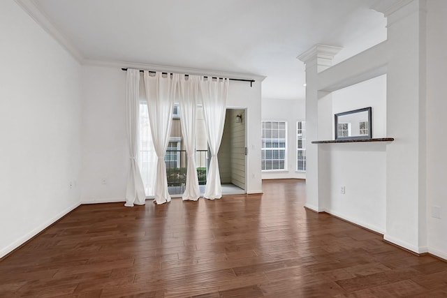 interior space with baseboards, ornamental molding, and wood finished floors