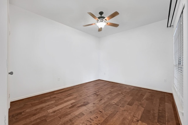 unfurnished room with a ceiling fan, baseboards, and wood finished floors