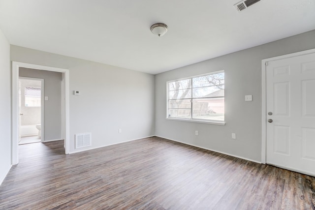 unfurnished living room featuring plenty of natural light, wood finished floors, and visible vents