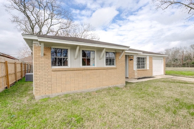 exterior space with a garage, a front lawn, fence, brick siding, and central air condition unit