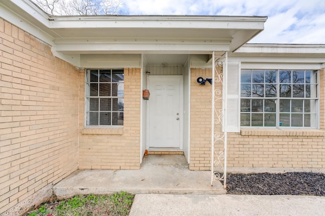 view of exterior entry featuring brick siding