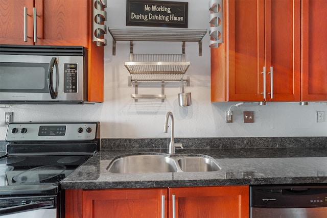 kitchen featuring a sink, dark stone counters, and appliances with stainless steel finishes
