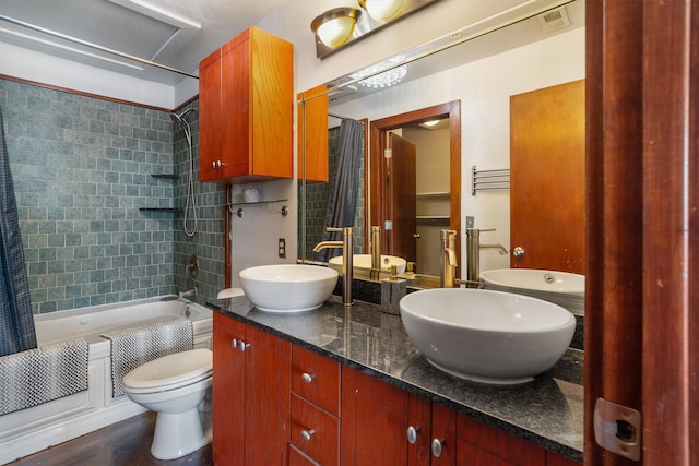 bathroom with shower / bath combo with shower curtain, a sink, visible vents, and toilet