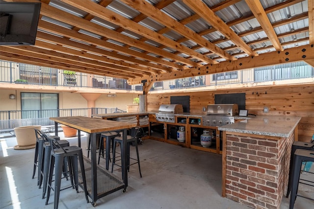 view of patio with outdoor wet bar, a grill, and area for grilling