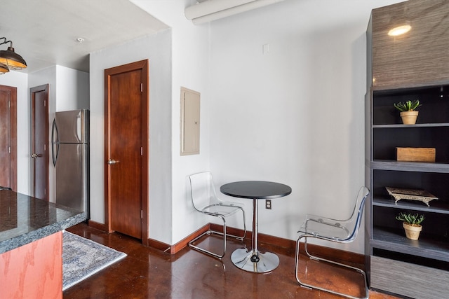 interior space with baseboards, finished concrete flooring, and electric panel