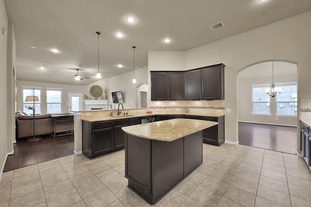 7610 Willow School Dr, Spring, TX 77389 - kitchen featuring visible vents, a peninsula, arched walkways, ceiling fan with notable chandelier, and backsplash