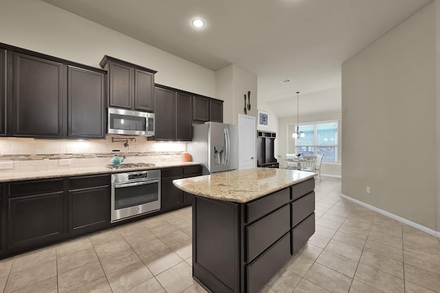7610 Willow School Dr, Spring, TX 77389 - kitchen featuring light stone countertops, appliances with stainless steel finishes, a center island, light tile patterned floors, and tasteful backsplash