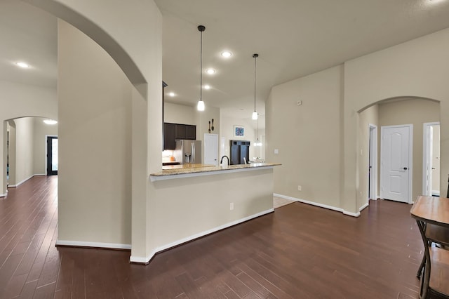 7610 Willow School Dr, Spring, TX 77389 - kitchen featuring dark wood-style flooring, stainless steel fridge with ice dispenser, arched walkways, baseboards, and refrigerator