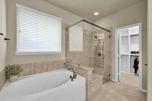 7610 Willow School Dr, Spring, TX 77389 - full bathroom featuring a walk in closet, a jetted tub, tile patterned floors, and a stall shower