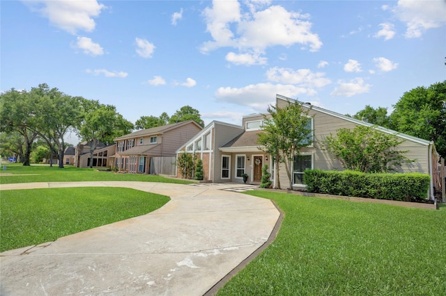 view of front of property featuring curved driveway and a front yard