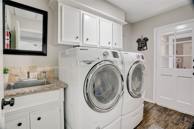 washroom with a sink, separate washer and dryer, dark wood finished floors, and cabinet space