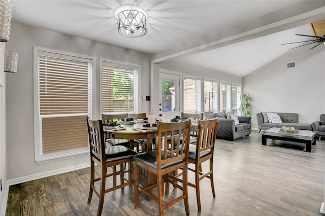 dining space with baseboards, a healthy amount of sunlight, lofted ceiling, and wood finished floors