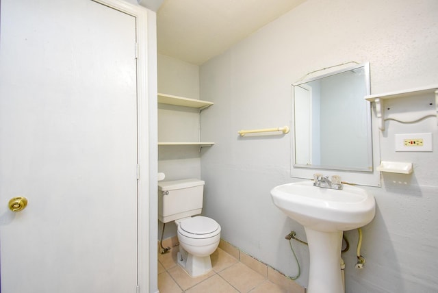 bathroom with toilet and tile patterned flooring