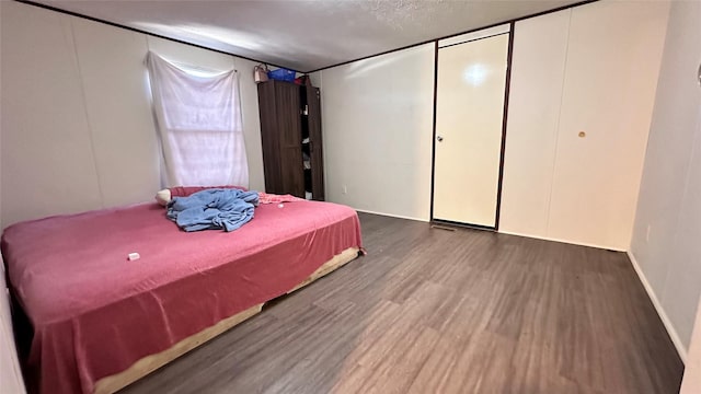 bedroom featuring a textured ceiling and wood finished floors