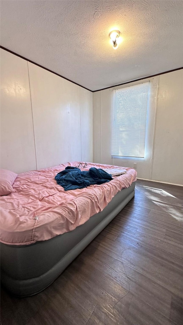 bedroom featuring a textured ceiling and wood finished floors