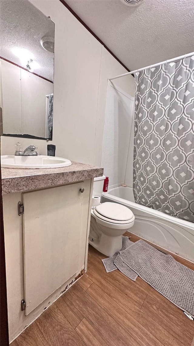 full bath featuring vanity, shower / tub combo with curtain, a textured ceiling, and wood finished floors