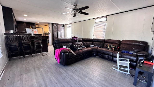 living area with a ceiling fan and light wood finished floors