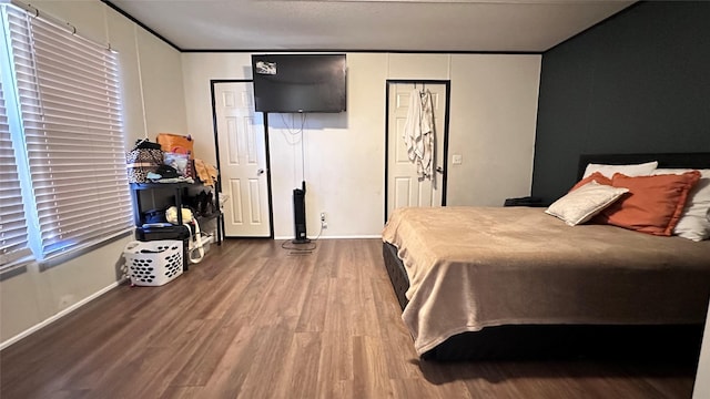 bedroom with crown molding, baseboards, and wood finished floors