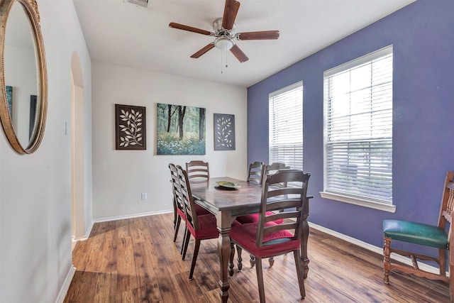 dining area with baseboards, a ceiling fan, and wood finished floors