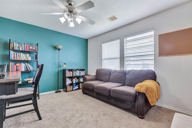 carpeted office with visible vents, baseboards, and ceiling fan