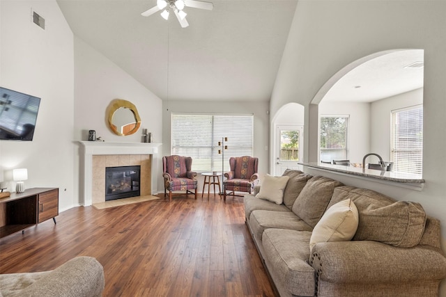 31611 Cape May Ct, Spring, TX 77386 - living room featuring arched walkways, wood-type flooring, ceiling fan, high vaulted ceiling, and a tile fireplace