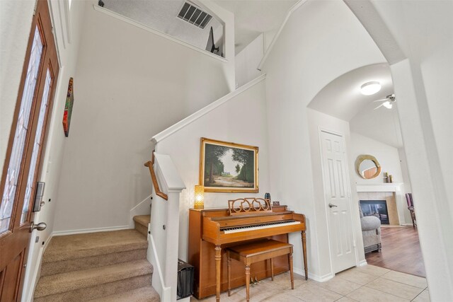 31611 Cape May Ct, Spring, TX 77386 - staircase featuring arched walkways, a ceiling fan, tile patterned floors, baseboards, and a high ceiling
