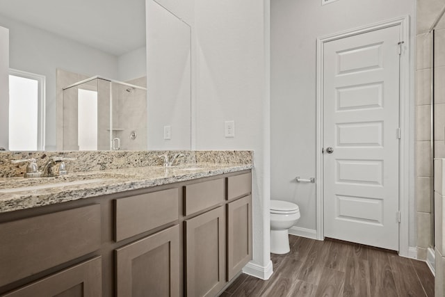 2340 Mooneye Ct, Conroe, TX 77384 - full bathroom featuring a sink, double vanity, toilet, wood finished floors, and a stall shower