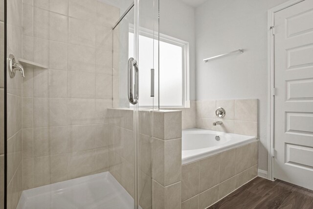2340 Mooneye Ct, Conroe, TX 77384 - bathroom with a stall shower, a bath, and wood finished floors