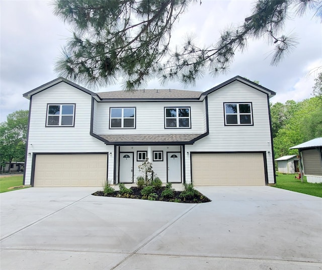 view of front facade featuring a garage, driveway, and a shingled roof