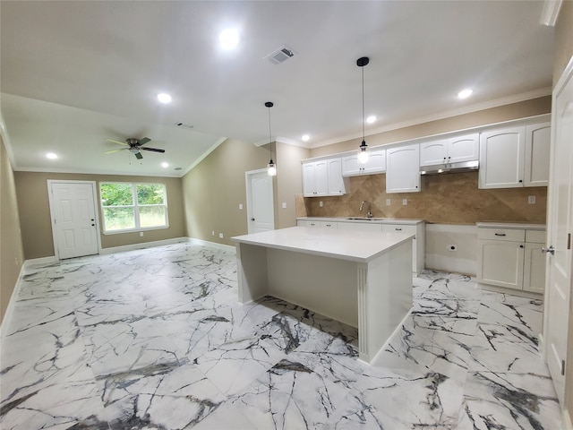 kitchen featuring ornamental molding, under cabinet range hood, ceiling fan, and visible vents