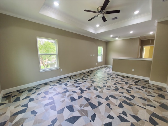 spare room featuring a raised ceiling, ornamental molding, attic access, and visible vents