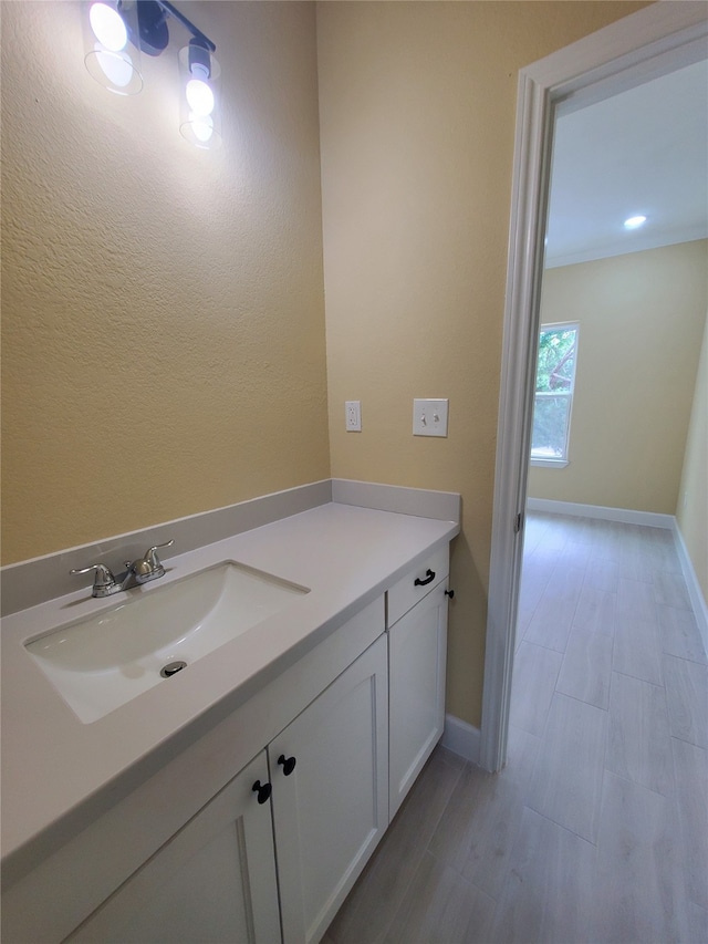 bathroom with baseboards, wood finished floors, and vanity