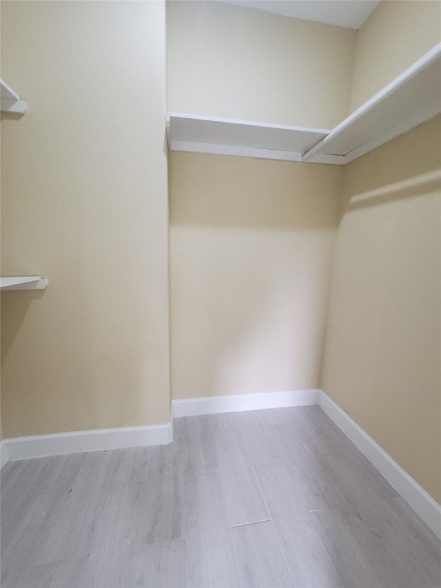 walk in closet with wood finished floors