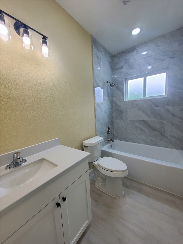 full bathroom featuring vanity, washtub / shower combination, wood finished floors, and toilet
