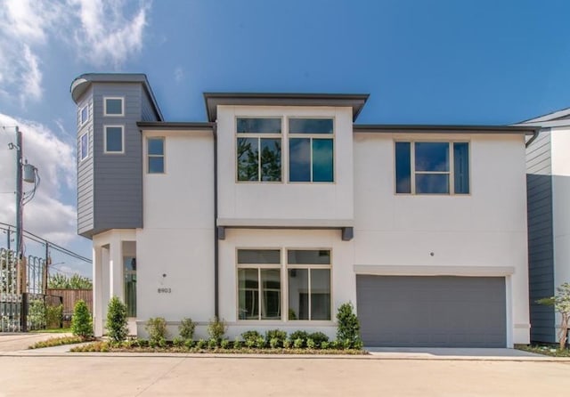 view of front of home with an attached garage, stucco siding, and concrete driveway