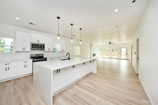 600 Rd 5105, Cleveland, TX 77327 - kitchen with a healthy amount of sunlight, visible vents, appliances with stainless steel finishes, open floor plan, and light wood-style flooring