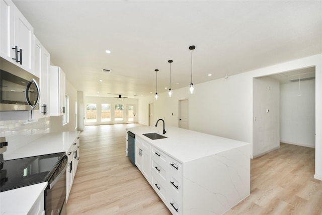 600 Rd 5105, Cleveland, TX 77327 - kitchen with open floor plan, electric range oven, stainless steel microwave, a sink, and light wood-style flooring