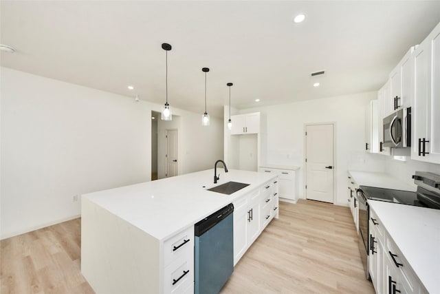 600 Rd 5105, Cleveland, TX 77327 - kitchen featuring appliances with stainless steel finishes, a sink, light wood finished floors, white cabinetry, and visible vents