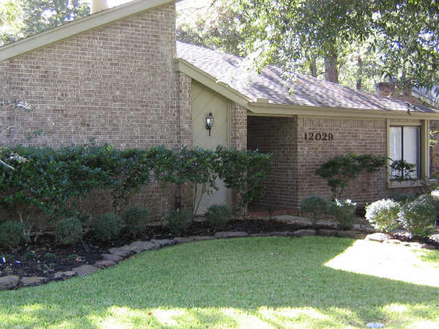 view of home's exterior with brick siding and a yard