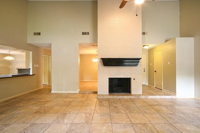 unfurnished living room featuring a high ceiling, ceiling fan, and visible vents